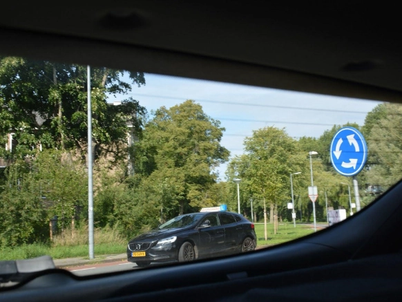 Rijschool Noord-Holland - Student met duimen omhoog naast lesauto